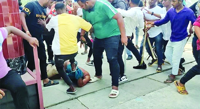 Activists of BCL kick out a BNP man during a clash in Sreenagar Upazila of Munshiganj district on Friday.