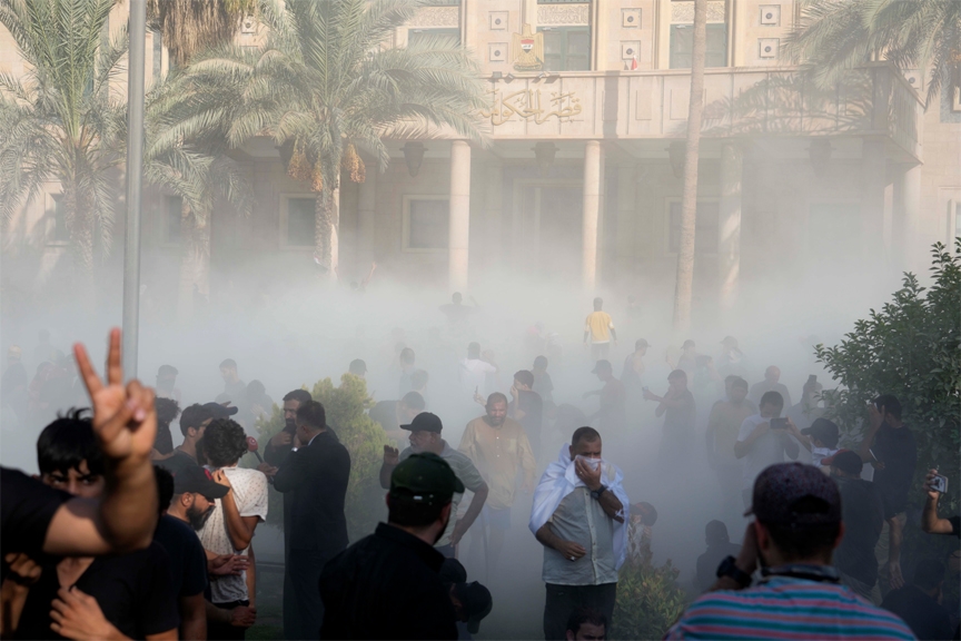 Iraqi security forces fire tear gas on followers of Shiite cleric Muqtada al-Sadr protesting inside the government palace grounds, in Baghdad, Iraq, Monday, Aug. 29, 2022.