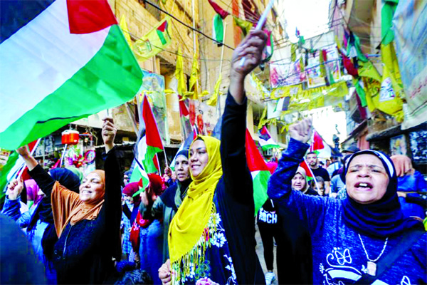 Palestinians wave their national flag and shout slogans against the Bahrain Conference.