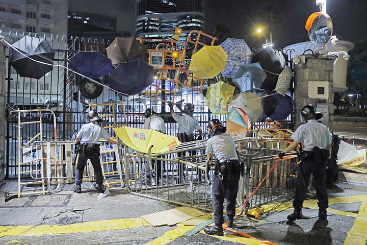 Riot police clear barricades blocked by protesters outside the police headquarters as thousands gathered to demand for an independent inquiry into a heavy-handed police crackdown at a protest earlier this month, in Hong Kong during the early hours of on T