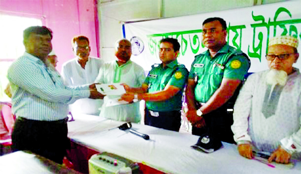 Senior Assistant Police Commissioner of Rampura Traffic Zone Md Humayun Kabir distributing traffic guidebooks among the dwellers under the Zone in the capital during a traffic awareness programme on Thursday. Traffic Inspector Biplob Bhowmik conducted the