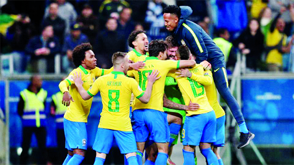 Brazil players celebrate winning the penalty shootout between Brazil and Paraguay at the Arena do Gremio, Porto Alegre, Brazil on Thursday.