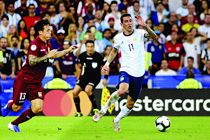 Argentina's Angel Di Maria (right) and Venezuela's Luis Manuel Seijas go for the ball during a Copa America quarterfinal soccer match at the Maracana stadium in Rio de Janeiro, Brazil on Friday.