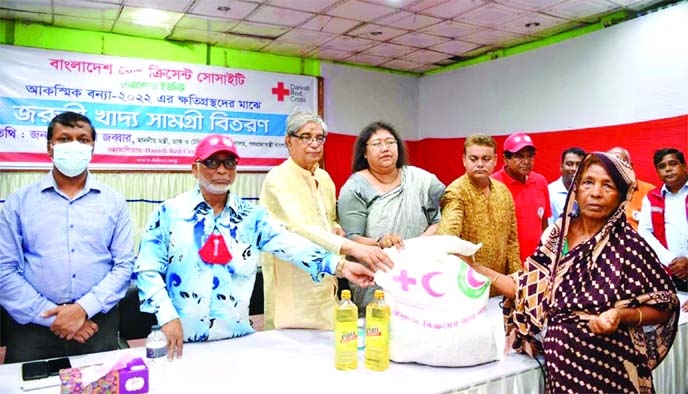 Post and Tele-communications Minister Mostofa Jabber distributes food item among the flood-hit families at Netrakona Public Hall on Thursday.