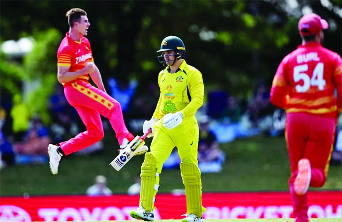 Australia's batsman Alex Carey (center) walks off after being dismissed by Zimbabwe's Brad Evans (left) during the third one-day international (ODI) cricket match between Australia and Zimbabwe at the Riverway Stadium in Townsville on Saturday.
