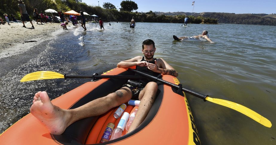 Luis Vazquez, of Fairfield, sits in his inflatable boat looking for the perfect song to play before heading out onto the water on Labor Day in Benicia, Calif., on Monday, Sept. 5, 2022.