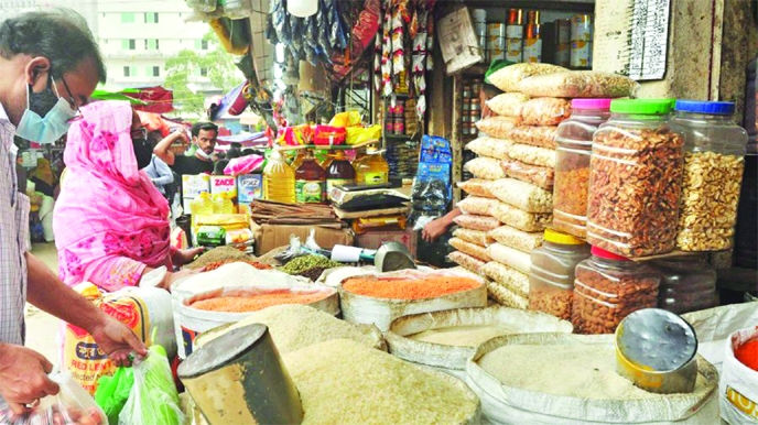 Customers stand in front of a store in city’s Karwan Bazar area on Friday to purchase daily essentials.