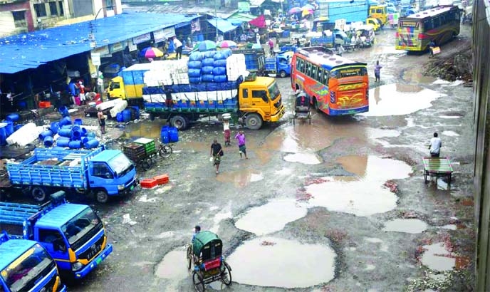 Vehicles struggle to ply on Dhaka-Chattogram Highway at Jatrabari wholesale kitchen market in the capital as large potholes have developed on it due to lack of repair work. This photo was taken on Friday.