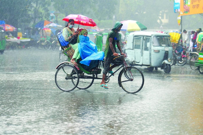 Three passengers get drench with rain water by a rickshaw taking an umbrella over their heads at TSC area on Dhaka University campus on Saturday.