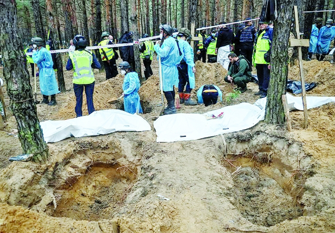 Members of Ukrainian Emergency Service, police and experts work at a mass burial site during an exhumation, as Russia's attack on Ukraine continues, in the town of Izium on Saturday.