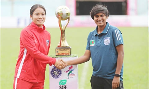 Captain of Bangladesh Women's Football team Sabina Khatun (right) and Captain of Nepal Women's Football team Anjila Tumbapo Subba shaking hands in front of the SAFF Women's Championship trophy at Kathmandu, the capital city of Nepal recently.