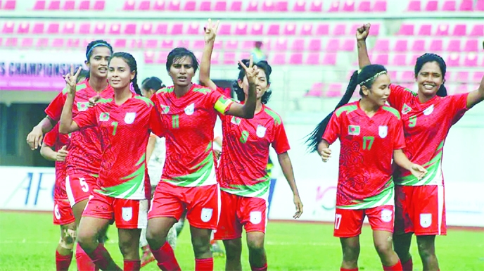 Players of Bangladesh Women's Football team showing victory sign after beating Nepal Women's Football team in the final of the SAFF Women's Championship at Dasharath Rangasala Stadium in Kathmandu, the capital city of Nepal on Monday.