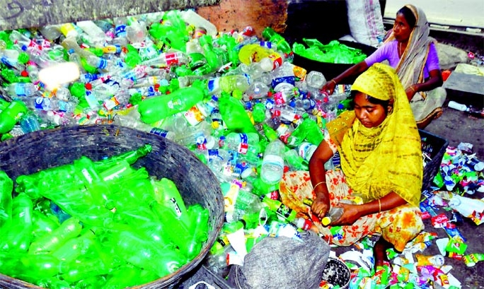 Two workers are seen doing the work of plastic waste recycling in Trimohoni area in the capital on Wednesday.