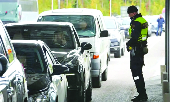 A Finnish border guard stands near cars queuing in Vaalimaa, Finland, to enter the country from Russia on Friday.