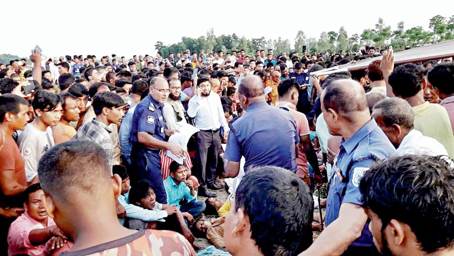 People gather on the bank of Karatoa River at Awliar ghat under Boda upazila in Panchagarh on Sunday afternoon as police count bodies of the deceased in a tragic boat capsize. Agency photo